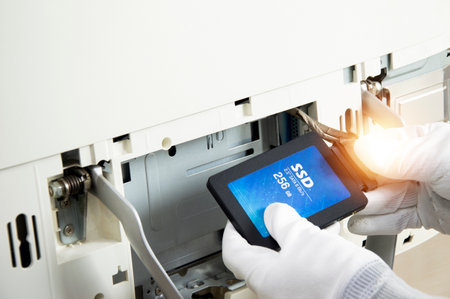 2.5 inch ssd hard drive that technician is installing in computerの写真素材