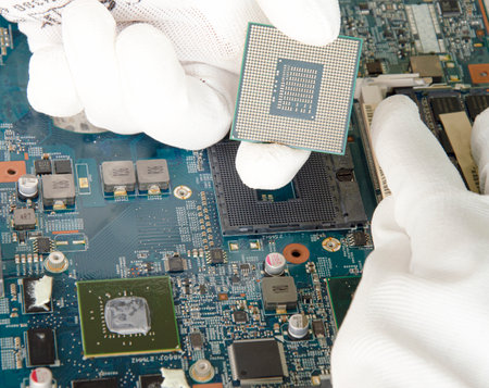 image of a mechanic repairing computer motherboard, electronic motherboard repairの写真素材