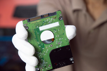 Hard disks are still popular in use today, holding a hard disk in your hand.の写真素材