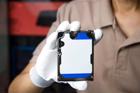 Hard disks are still popular in use today, holding a hard disk in your hand.の写真素材