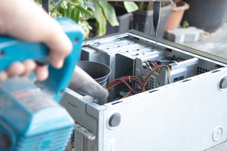 Cleaning a dusty computer with a blower.の写真素材