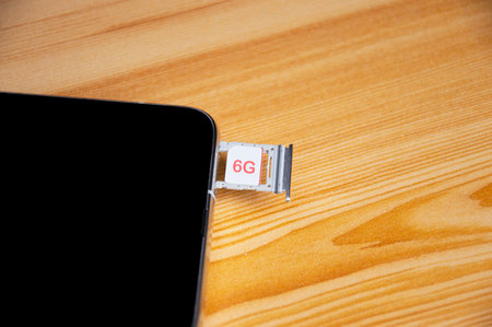 6G technology, Internet concept. SIM card in smartphone tray on wooden table, closeup 6G network concept, high speed mobile internet New age network, business concept, modern technology internet and networkの写真素材