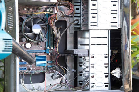 Cleaning a dusty computer with a blower.の写真素材