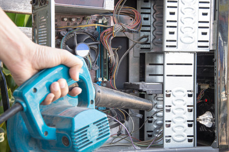 Cleaning a dusty computer with a blower.の写真素材