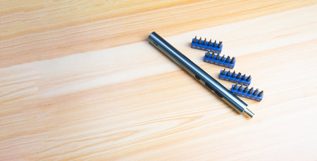 Picture of a mini electric screwdriver, interchangeable tip, placed on a wooden floor.の写真素材