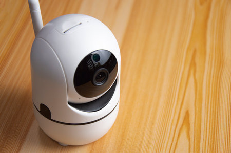 White IP camera placed on wooden floor
