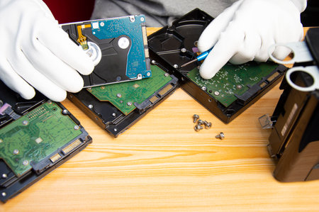 technician is repairing hard drive, hard drive used to store dataの写真素材