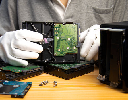 3.5 inch hard drive is still popular today, technician holding hard drive in handの写真素材