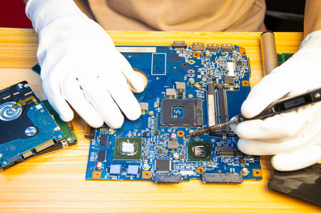 Technician repairing computer motherboard, notebook motherboardの写真素材