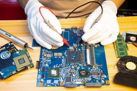 Technician repairing computer motherboard, notebook motherboardの写真素材
