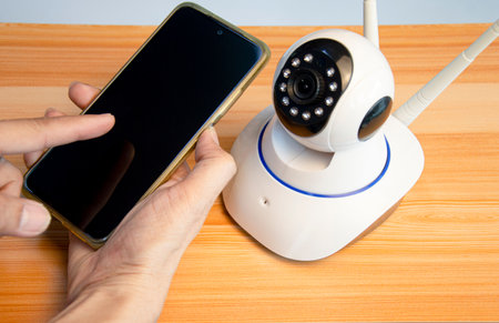man using smart phone with ip cameraの写真素材