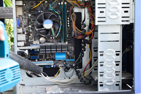 Photograph of a technician blowing dust from a computerの写真素材
