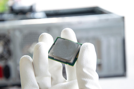 An image of a technician holding a CPU in his hand.