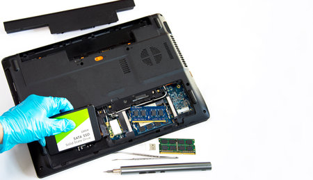 Technician installing ssd drive in old computer, upgrading computer