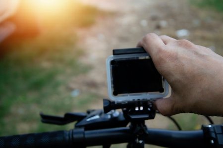 Male hand adjusting action camera on bicycleの写真素材