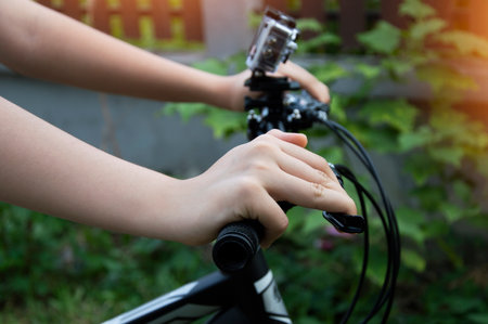 Woman's hand holding the handlebars of a mountain bikeの写真素材