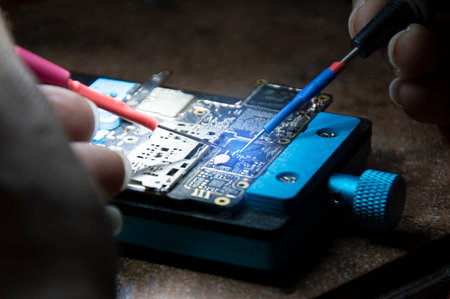 Side view of mechanic doing repairs Smartphone motherboard, smartphone repair, circuit repair