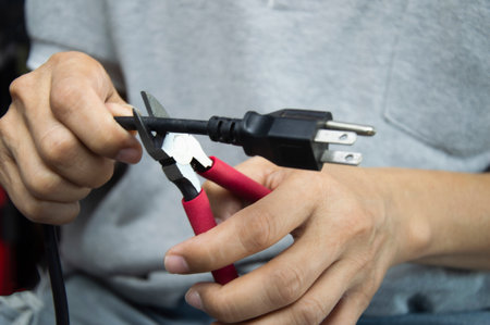 Technician uses red-handled pliers to cut wires, mechanic's tools