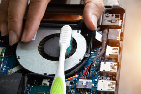 Technician is cleaning the dusty notebook ventilation fan.の写真素材