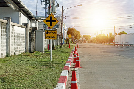 On the side of the road, at the edge of the road, the white and red lanes And there is a warning sign to drive slowly.の写真素材