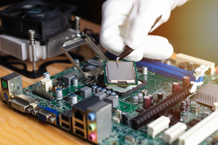 Technician inserting CPU into computer motherboard, computer repair technician