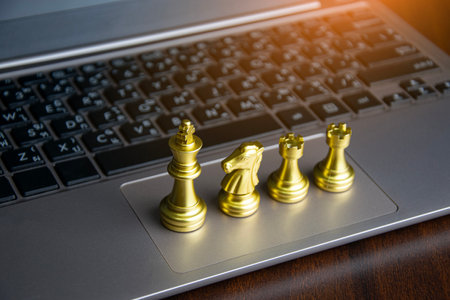 Golden chess king placed on laptop, corporate leadership conceptの写真素材