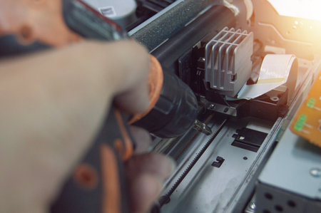 Side view of technician inspecting and repairing printer.の写真素材