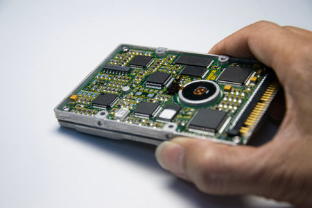 2.5 inch hard disk. Technician holding hard disk on white background.の写真素材