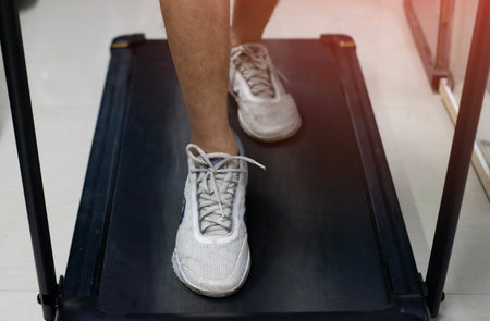 Asian man preparing to run on a treadmill