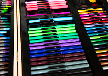 a box of art supplies with a variety of pens and pencilsの写真素材