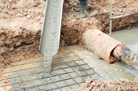 Workers are pouring cement on the construction site.