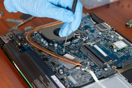 A technician is repairing the motherboard of a laptop computer.