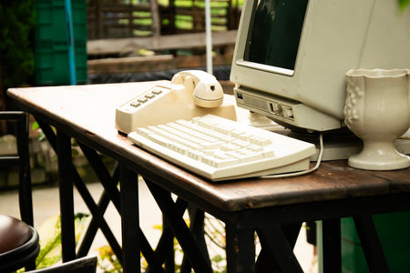 90s telephones and computers are displayed on a table.の写真素材