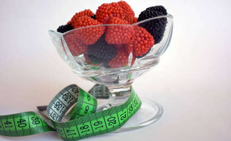 Berries in a glass bowl with measuring tapeの写真素材