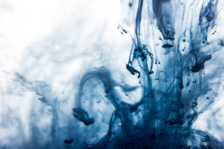 Macro, abstract. Blue watercolor paint drops in water with white backgroundの写真素材