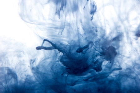 Macro, abstract. Blue watercolor paint drops in water with white backgroundの写真素材