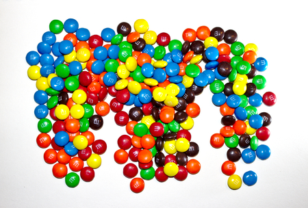 A pile of colorful coated chocolates M&M isolated on white backgroundのeditorial素材