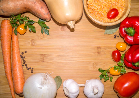 food & diet: ingredients for lentil soup on a wooden board with copy space in the centerの写真素材