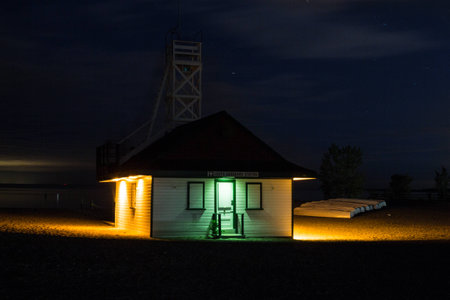 illuminated lifeguard station at a beach at nightの写真素材