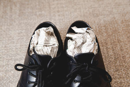Stuff the shoes with newspaper and dry them. Wet, damp shoes.の写真素材