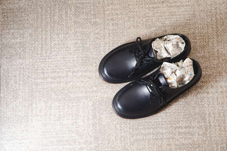 Stuff the shoes with newspaper and dry them. Wet, damp shoes.の写真素材