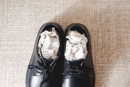 Stuff the shoes with newspaper and dry them. Wet, damp shoes.の写真素材