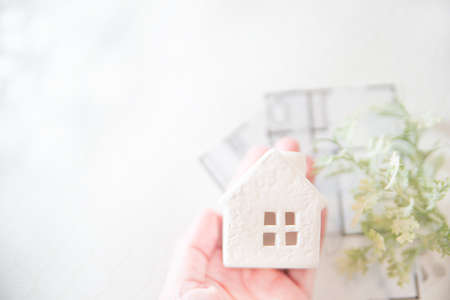 A house wrapped in a hand. Bright image of real estate, home, family, life etc.の写真素材