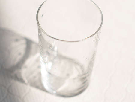 A glass or cup before pouring. A glass with water drops on it.の写真素材