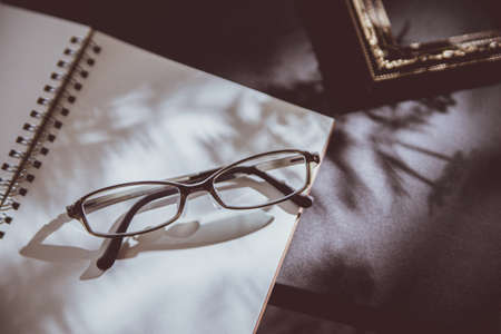 A desk with a pair of glasses on it.