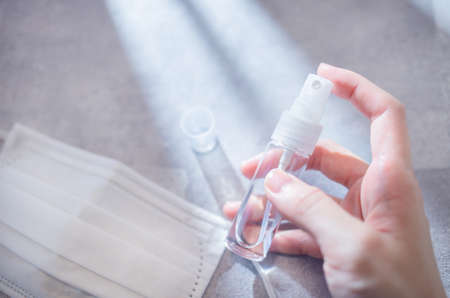 A state of holding a portable disinfectant spray in the room.の写真素材