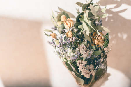 Yellow roses and dried eucalyptus flowers in the room.の写真素材