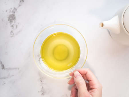 Drinking green and Japanese tea at home, poured in a kyusu into a transparent heat-resistant glass.の写真素材