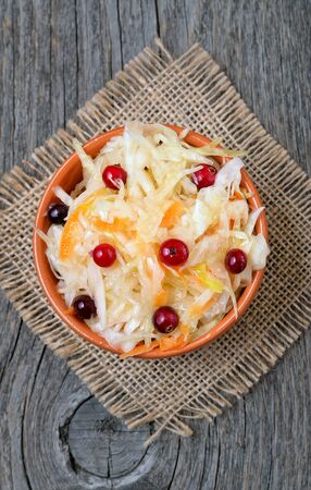Cabbage salad with cranberries on wooden background, top viewの写真素材