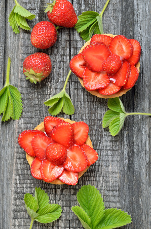 Fruit tartlets with fresh strawberries, top view. Summer dessertの写真素材